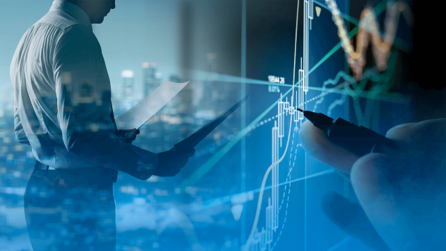 A foto mostra um homem em pé olhando para papeis na sua mão. Sobreposta, uma imagem de gráficos de plataforma de investimentos.