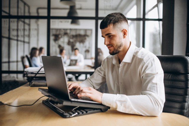 homem em escritório mexendo em notebook