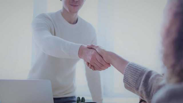 Na foto temos duas pessoas, dando as mãos, fechando um contrato. A imagem refere-se ao acordo entre um acionista, que investe em uma ação e a empresa a qual essa ação pertence. Palavra-chave de referência: meus dividendos.