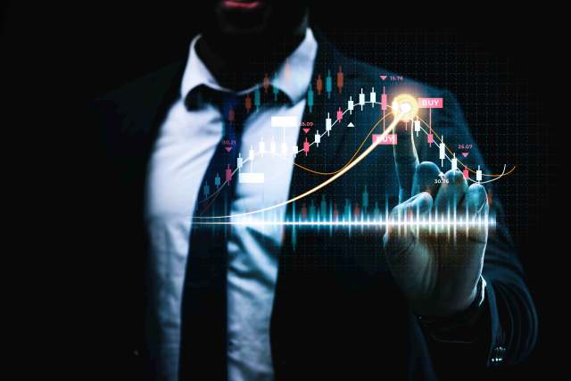 busto de terno com a mão apontando para um gráfico virtual de ações da bolsa de valores em referência aos robôs investidores