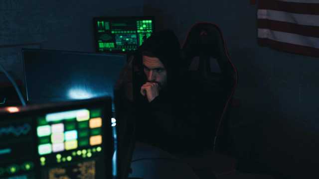 A imagem mostra um homem de moletom com capuz atualizando um computador em referência a um robô investidor.