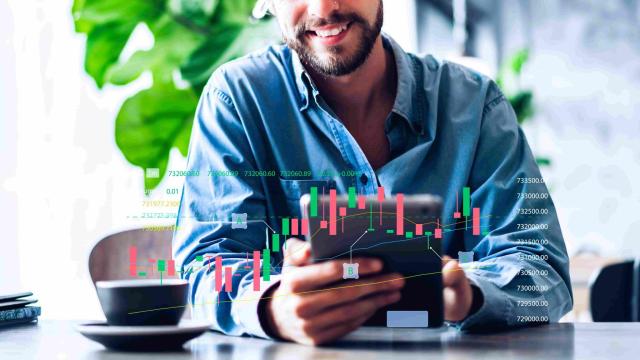 Homem analisa gráfico de volume financeiro em seu tablet, com foco na análise técnica do mercado de ações.
