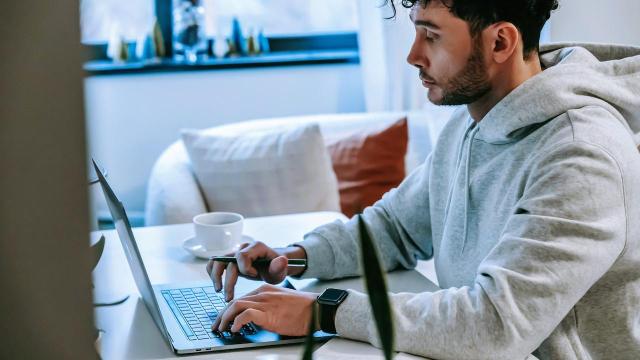 Homem em uma mesa de trabalho pesquisando em seu laptop sobre o que é e como calcular taxa referencial.