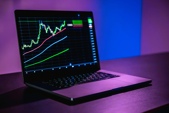 Notebook com gráficos de trade na tela, representando a plataforma Profit Pro